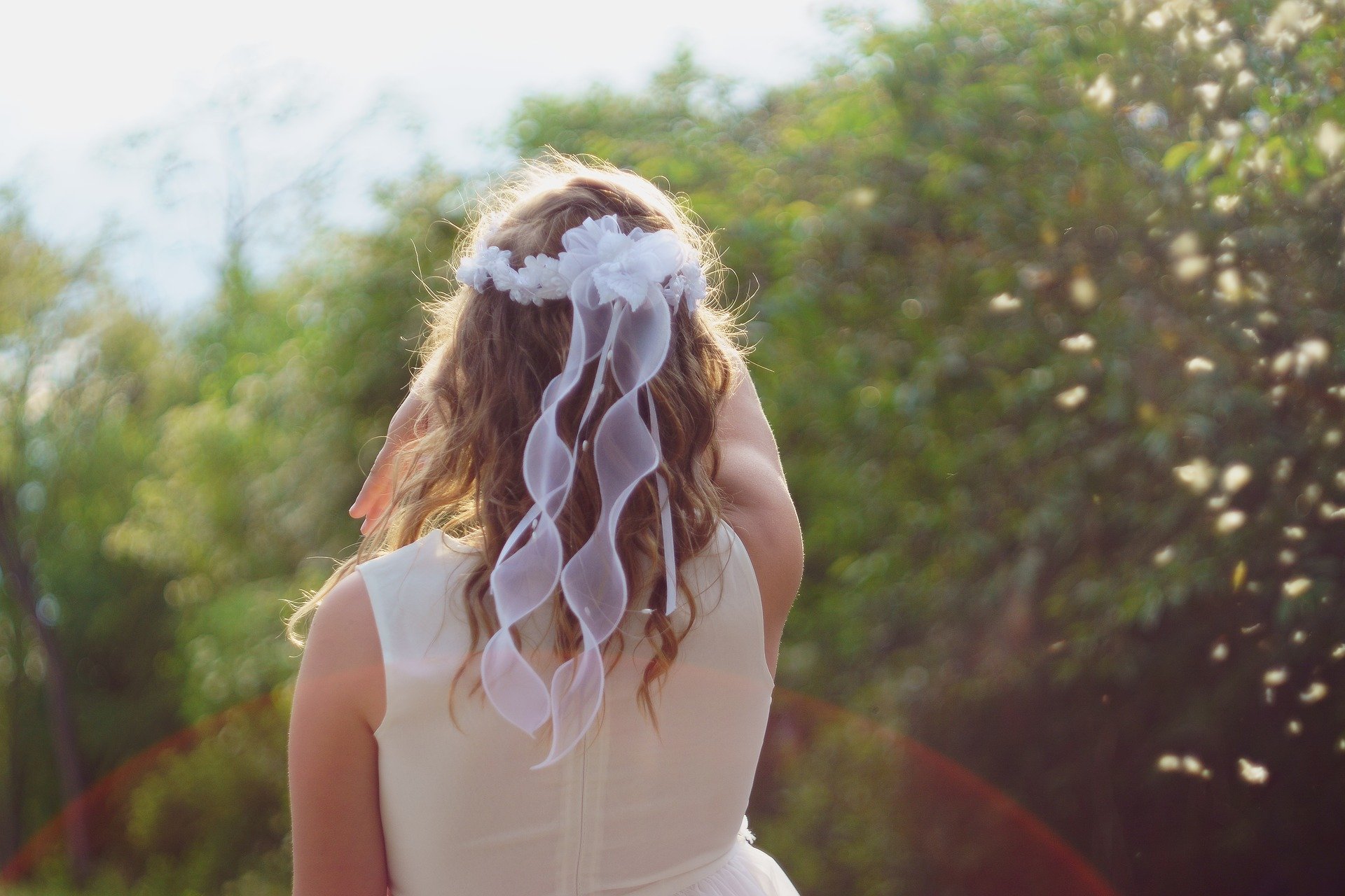 Una niña de espaldas, en su comunión. Foto: Vixrealitum / Pixabay