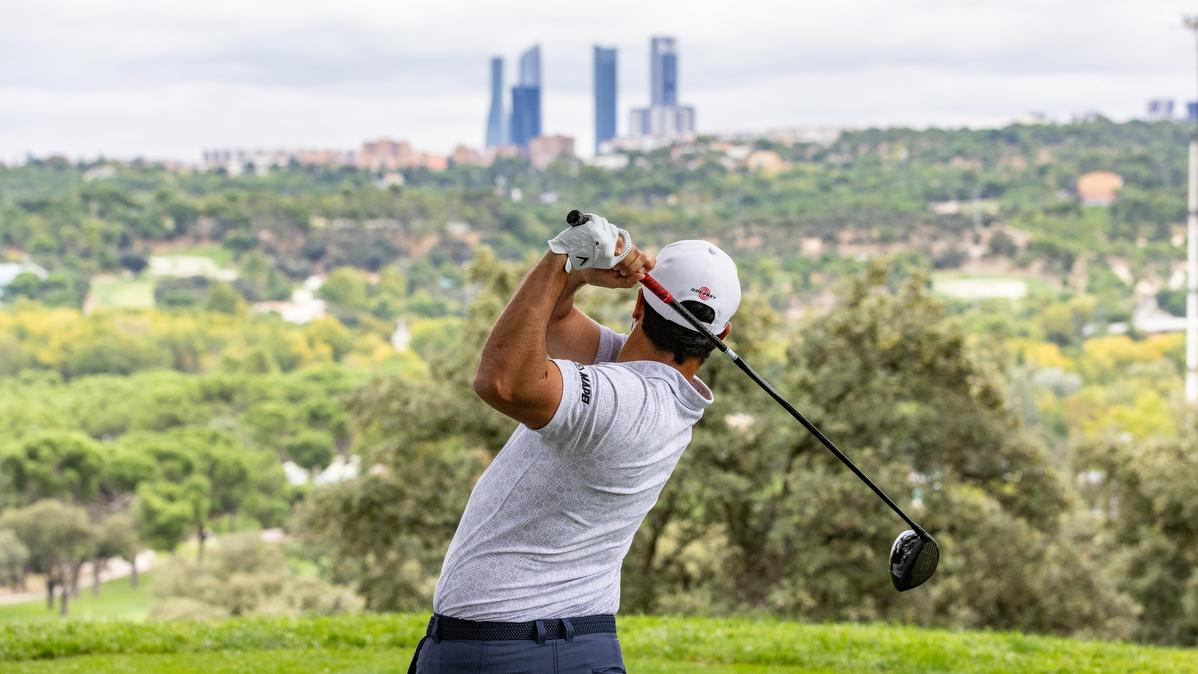 Un golfista sale del tee del hoyo 1 del Recorrido Negro del Real Club de Campo Villa de Madrid con las torres de Madrid al fondo. Foto: Miguel Ángel Ros / CCVM