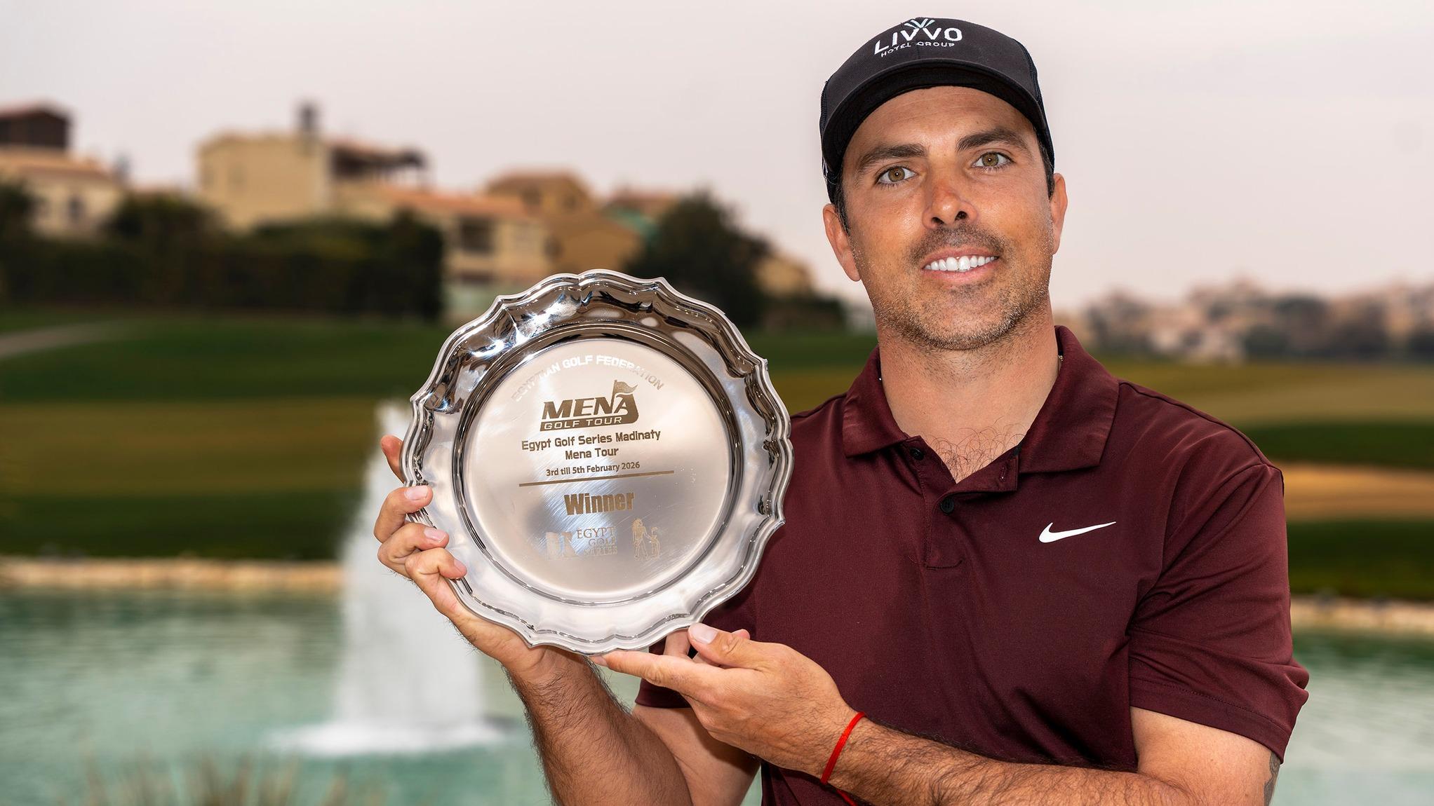 Juan Salama Monsalve muestra sonriente el trofeo de campeón del  Egypt Golf Series Madinaty. 