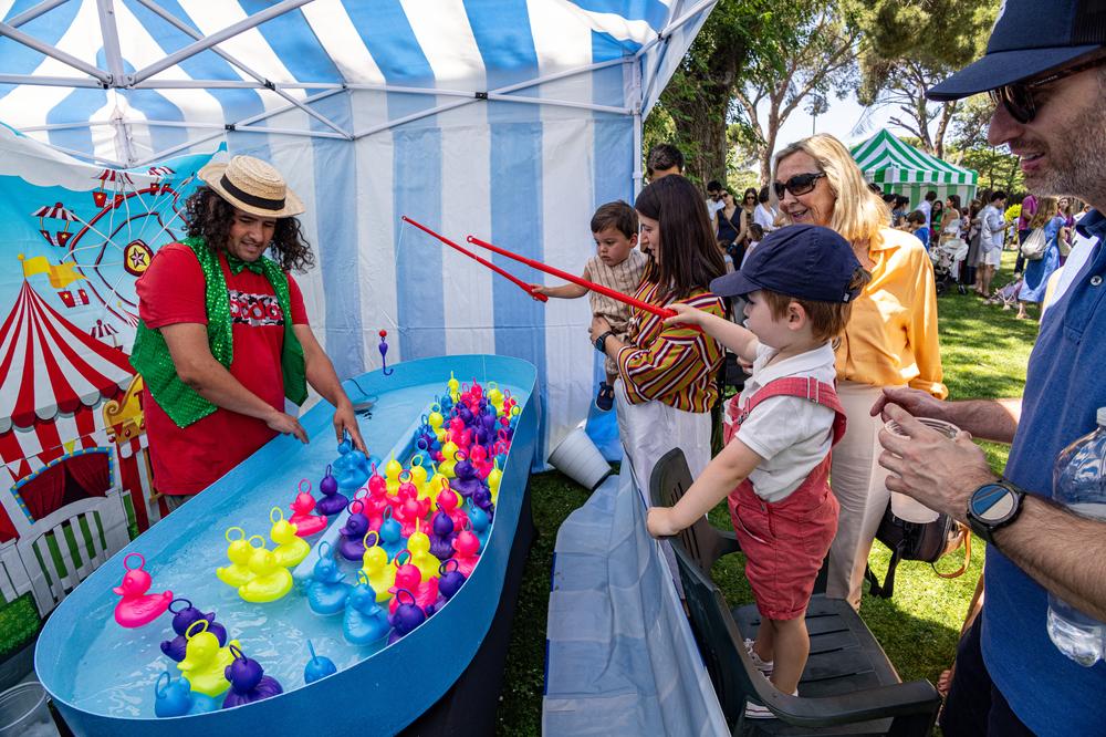Uno niños tratan de pescar patitos en una de las casetas de la Fiesta Familiar de Verano. Foto: Miguel Ángel Ros / RCCVM