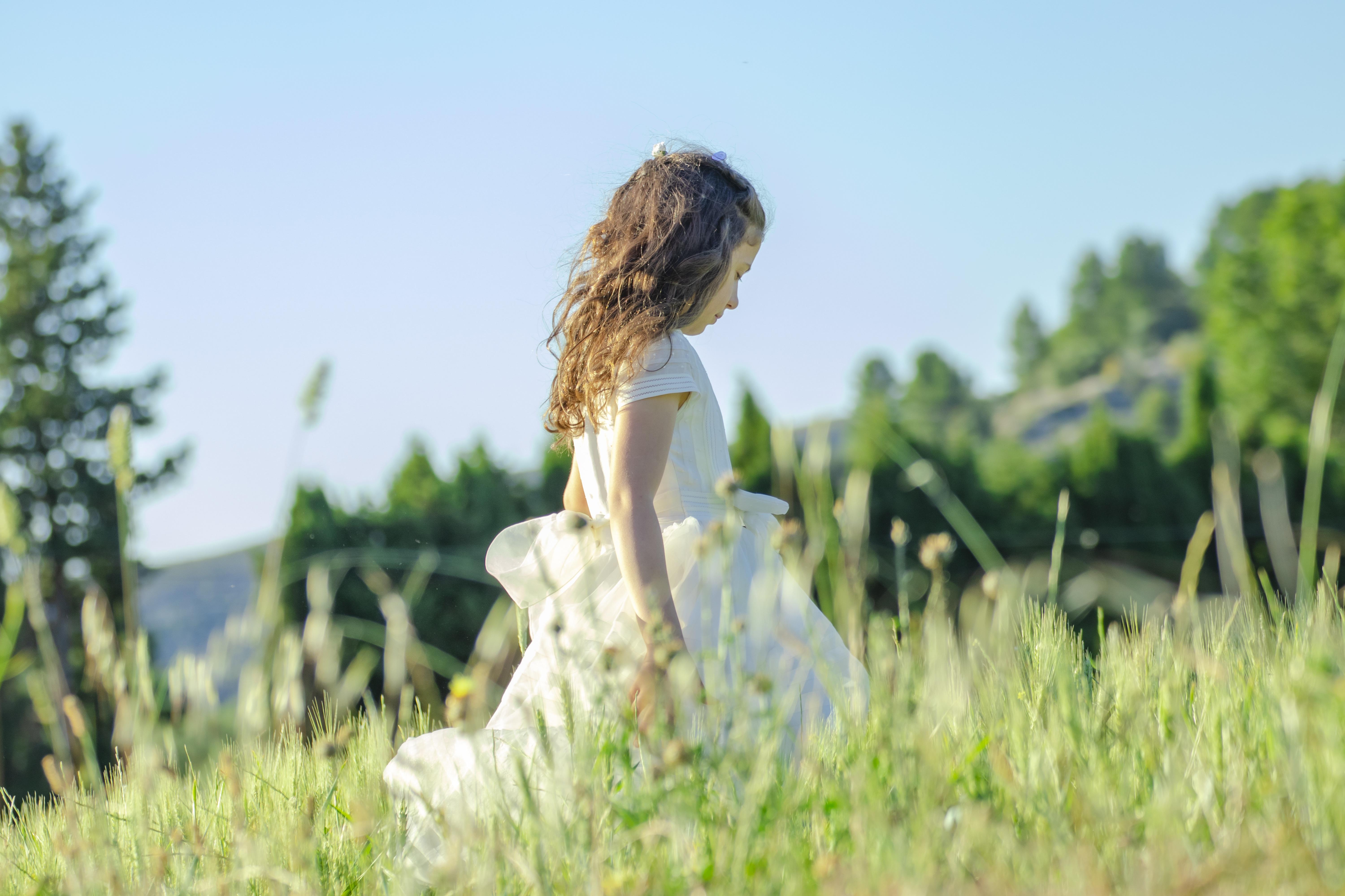 Una niña vestida de comunión pasea por el campo. Imagen de eginertex en Pixabay
