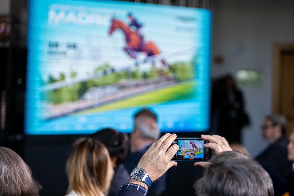 Un asistente a la presentación fotografía una imagen del cartel del concurso.