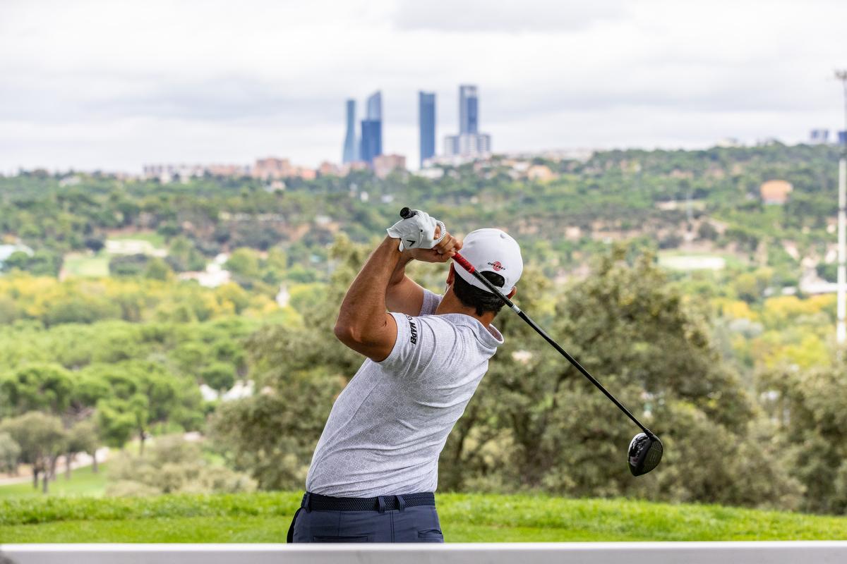 Un golfista sale del tee del hoyo 1 del Recorrido Negro del Real Club de Campo Villa de Madrid con las torres de Madrid al fondo. Foto: Miguel Ángel Ros / CCVM