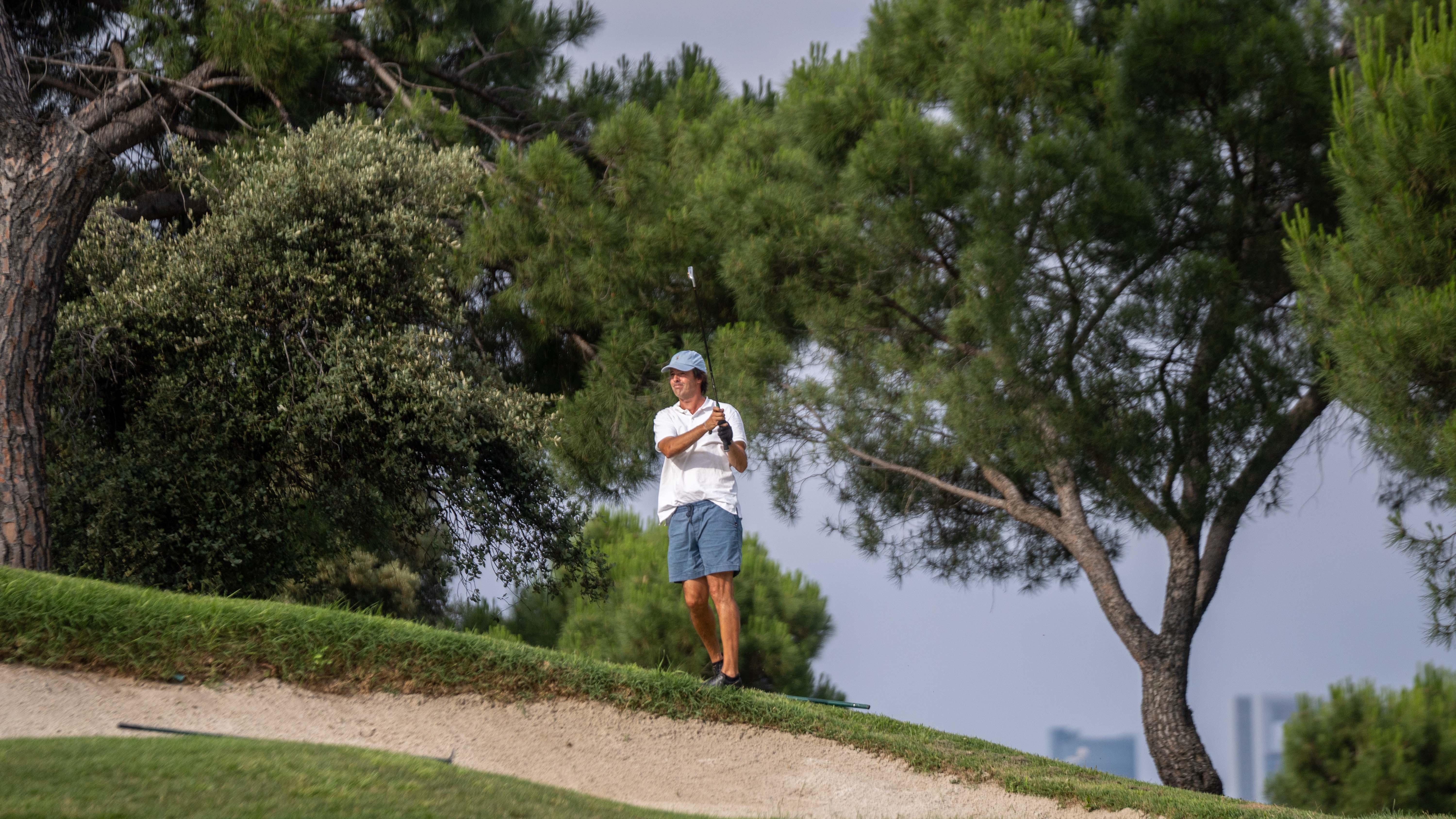 Un golfista sigue el vuelo de una bola.