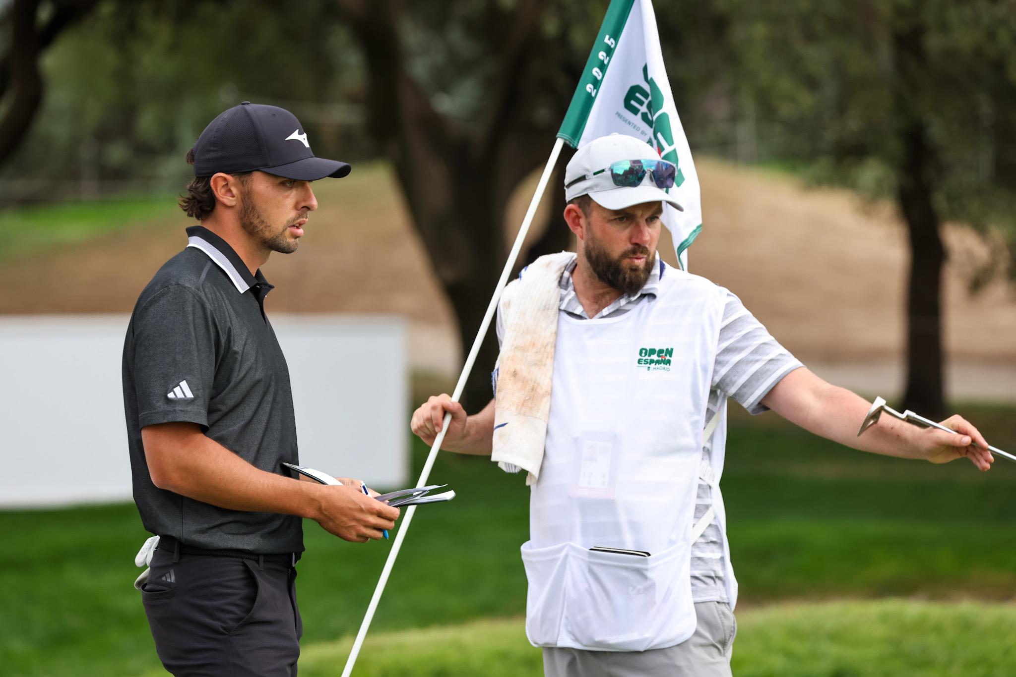 El líder, Marco Penge, habla con su caddie.