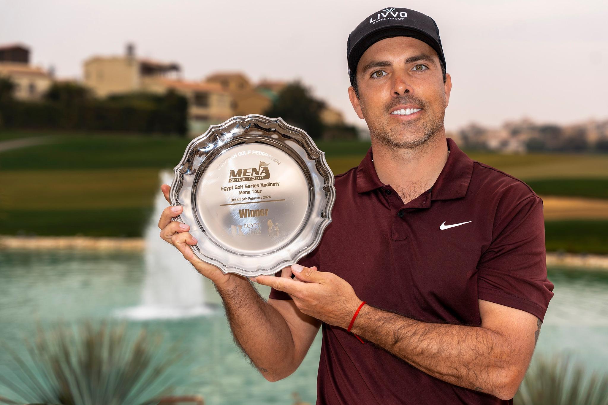 Juan Salama Monsalve muestra sonriente el trofeo de campeón del  Egypt Golf Series Madinaty. 