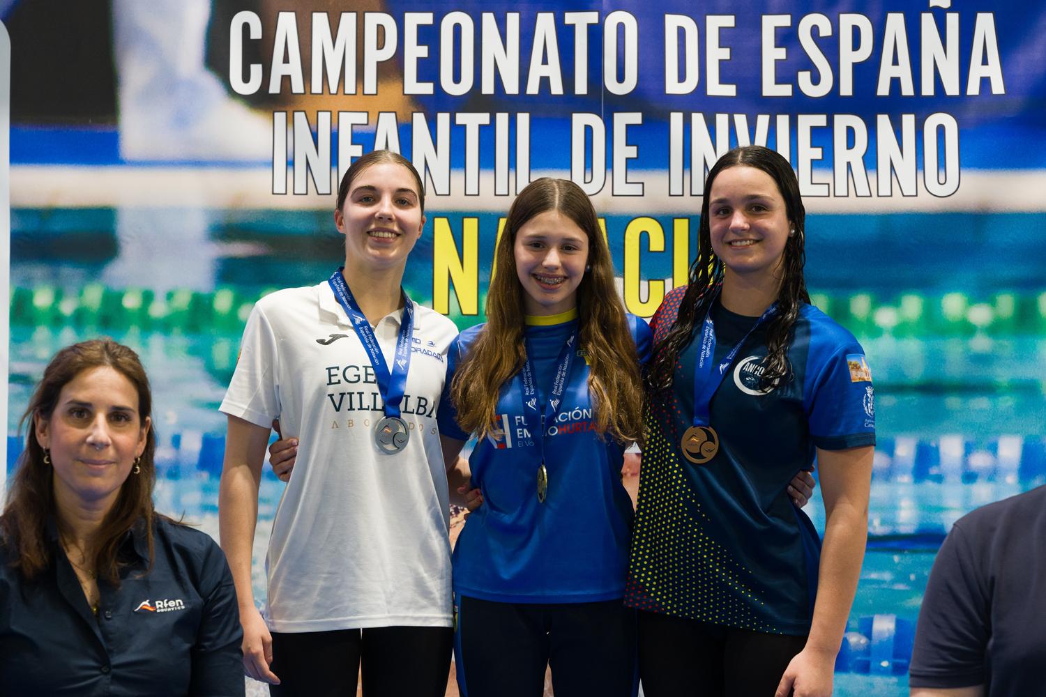 Lola Melgosa Ureña, en el podio, con uno de los oros conseguidos en el Campeonato de España infantil de invierno de natación. Fotos: David Chao