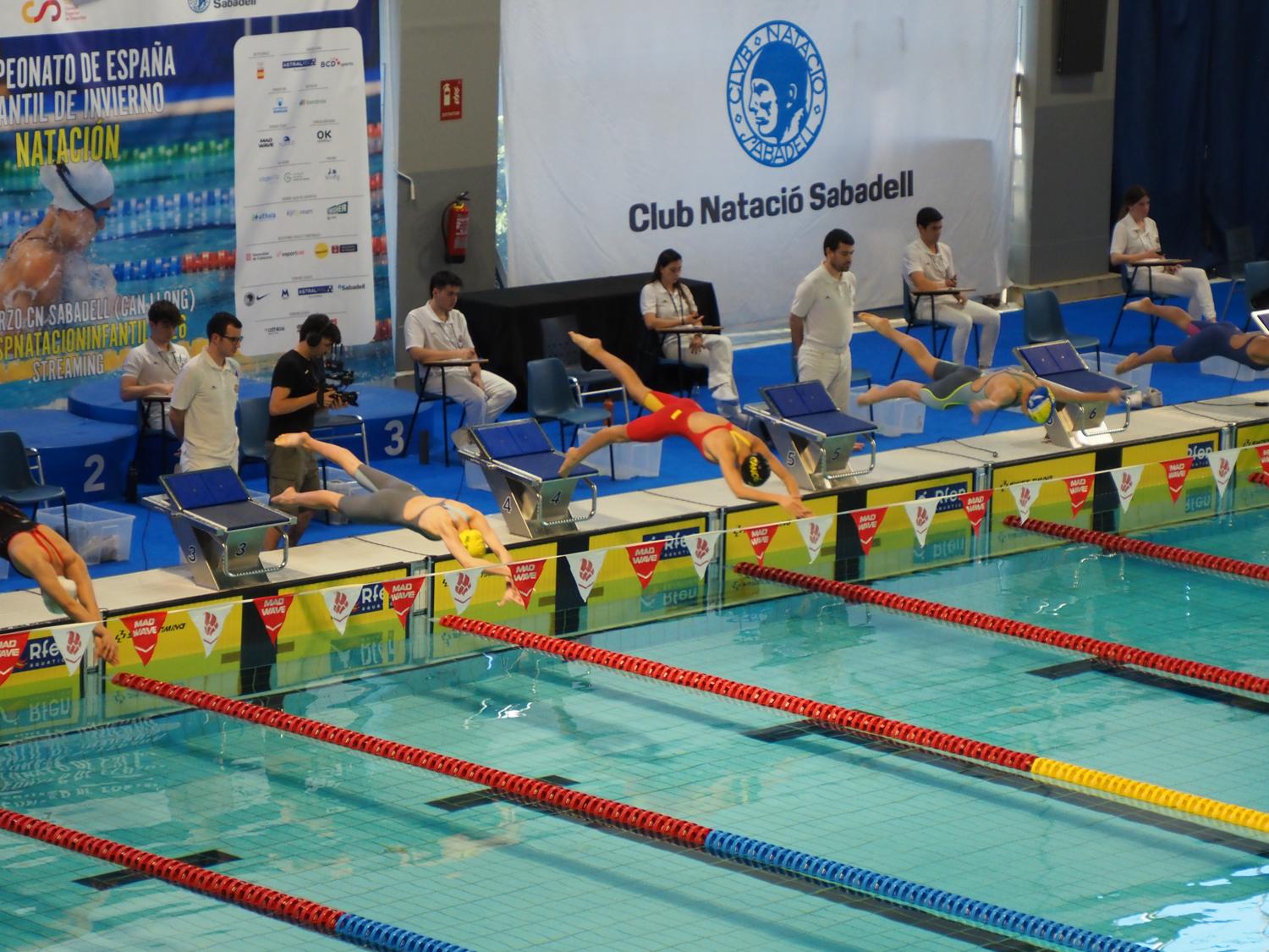 La nadadora Lola Molgasa (2ª, izda), se lanza al agua.