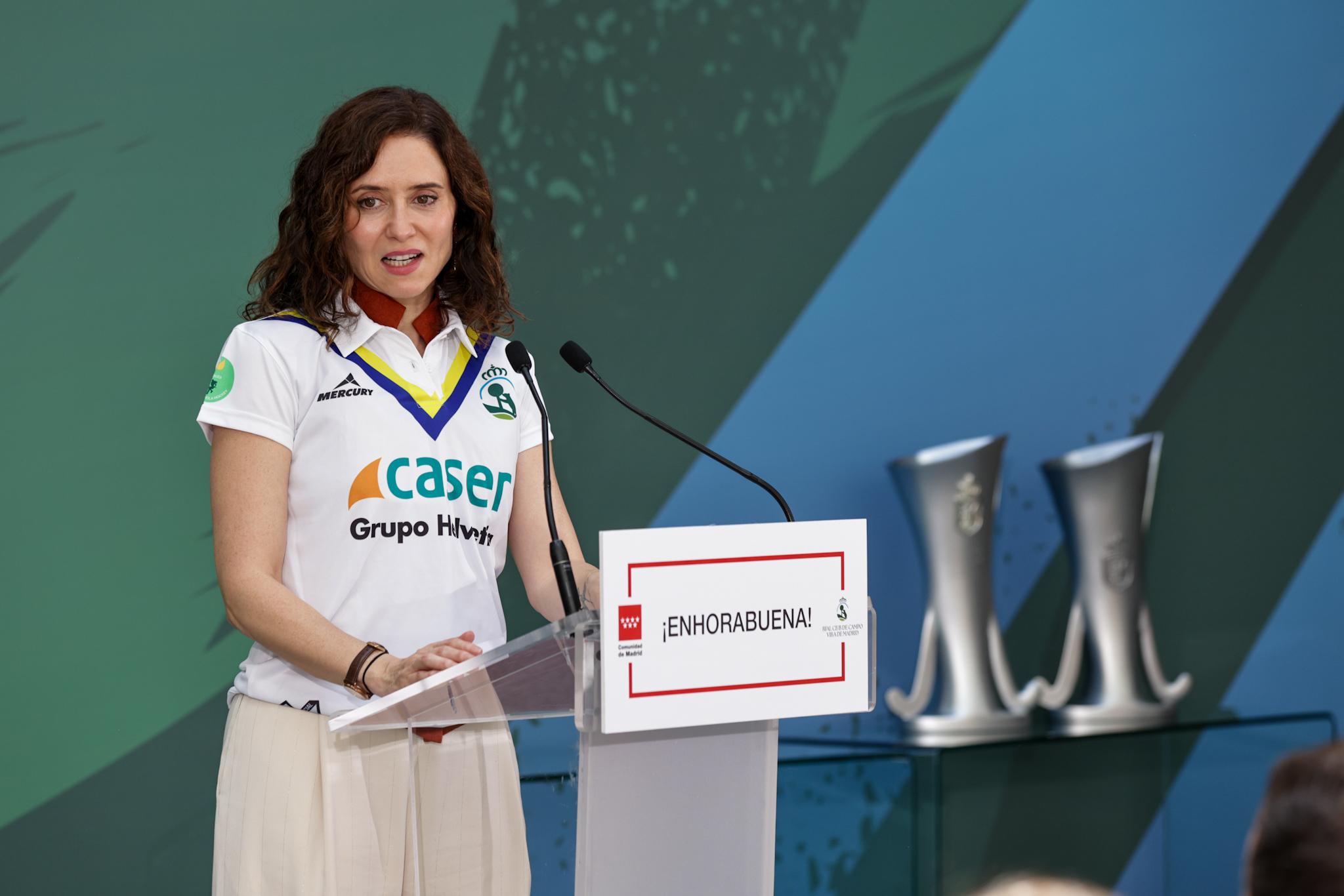 La presidenta de la Comunidad de Madrid, con las dos copas de la liga a la derecha.