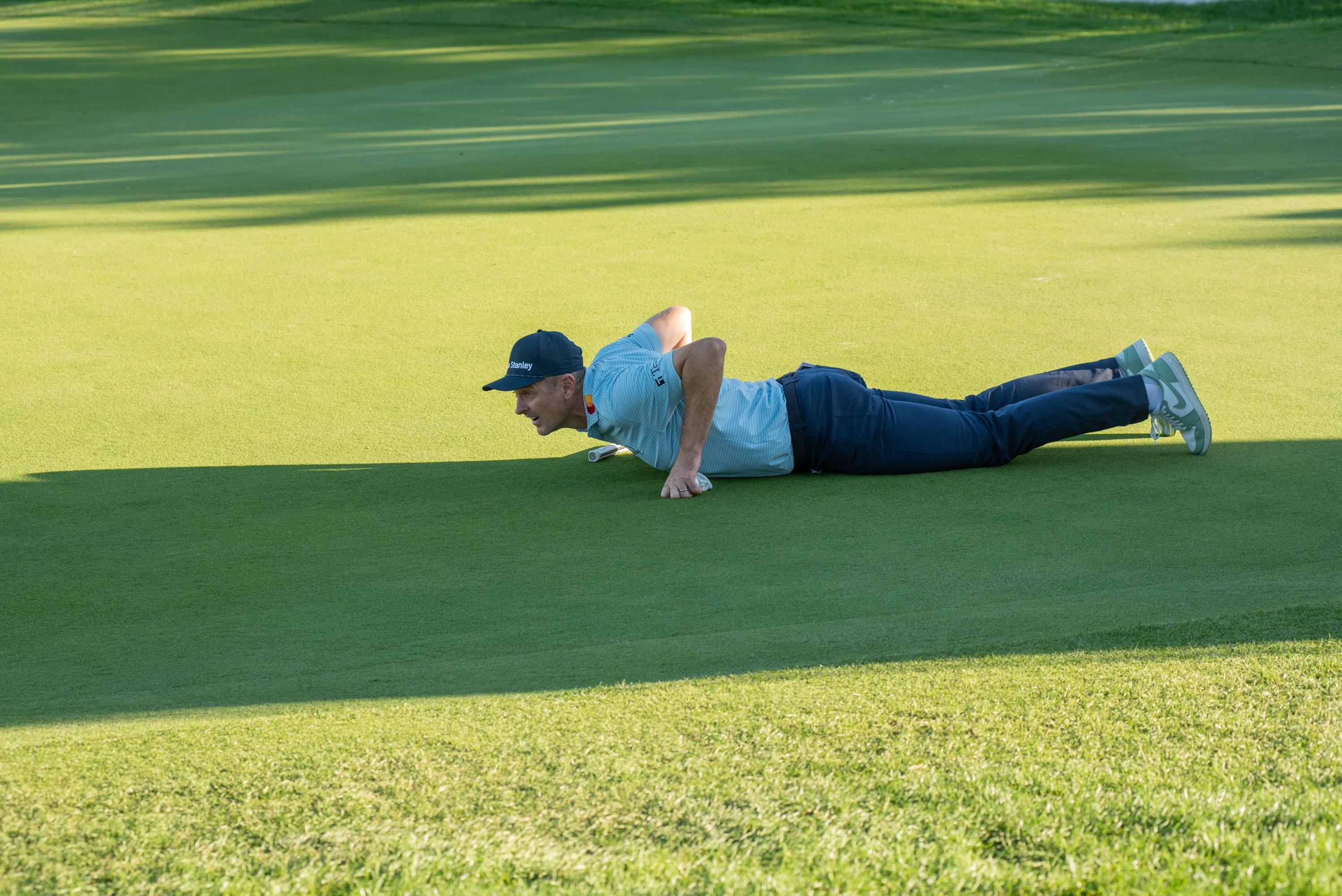 Justin Rose, tendido en el suelo para comprobar la caída de un green.