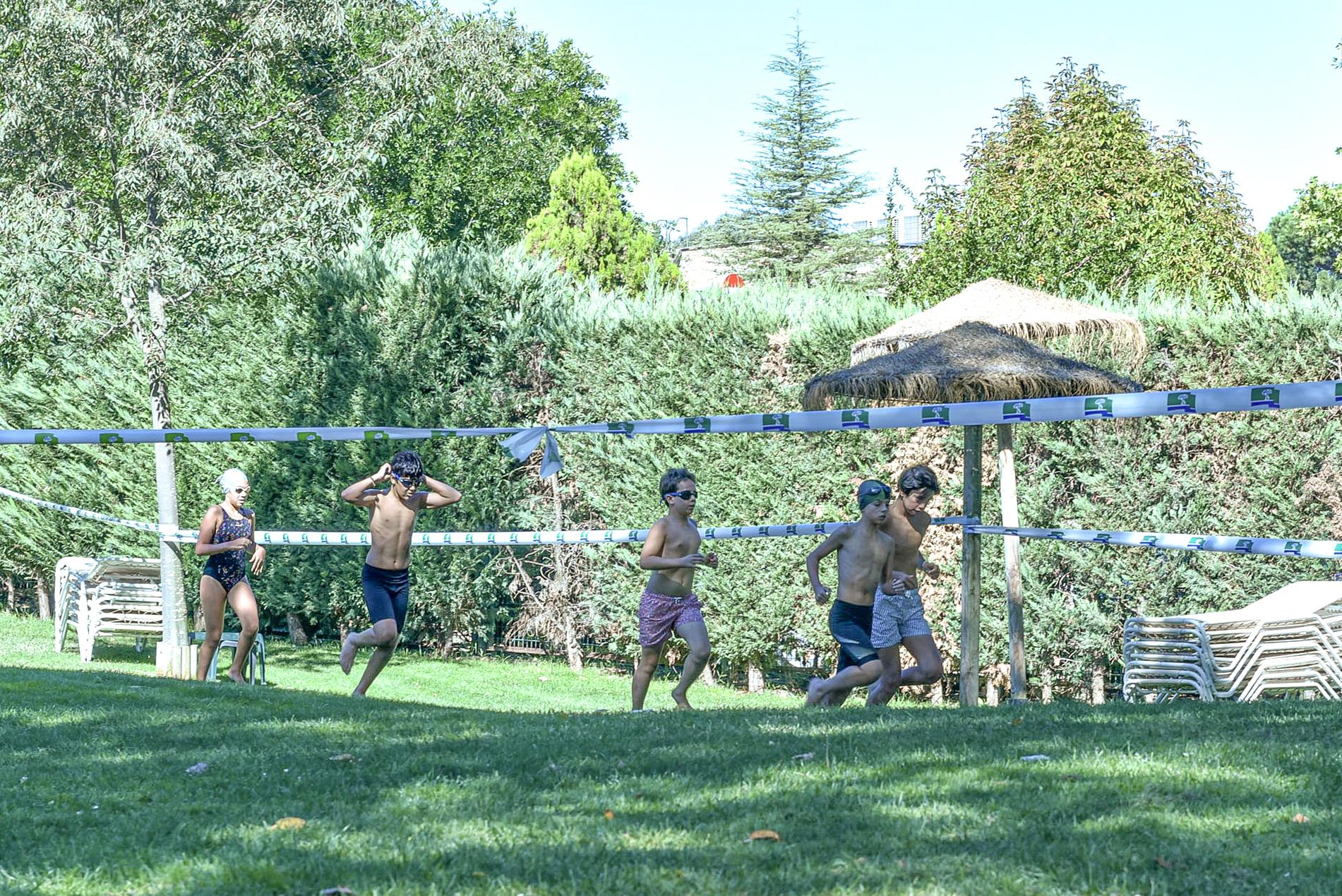 Niños corriendo en el área de piscinas del Club durante el Acuatlón.