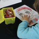Un niño pinta la cara de un arlequín. Foto: Ángel Yuste